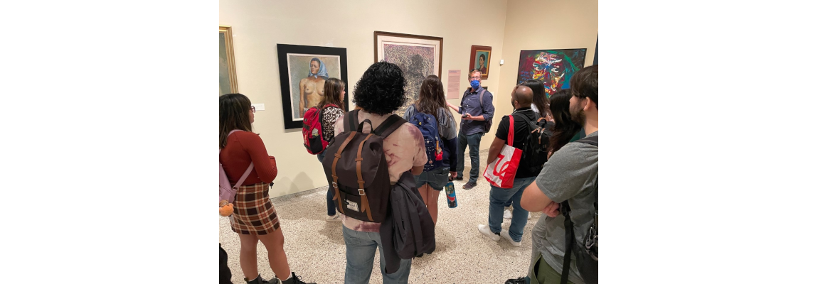 El profesor Auerbach le presenta a los estudiantes una de las obras de la exposición.